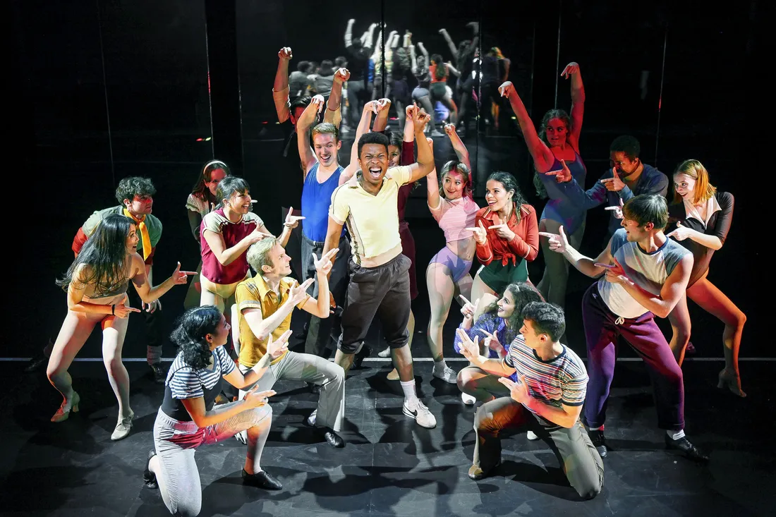 Student performing on stage with classmates.